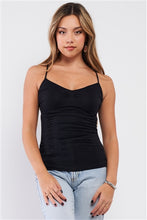 Young woman in jeans and the black, back cami top from Charmed & Fortunate’s online clothing store.