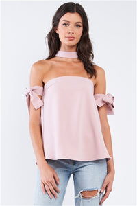 Charmed & Fortunate model wearing ladies’ apparel dusty rose bow tie, T-silhouette back halter top with ribbon sleeves.
