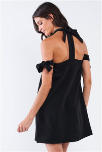 Charmed & Fortunate model wearing ladies’ apparel black bow tie, T-silhouette, back-tie ribbon mini-tube dress.